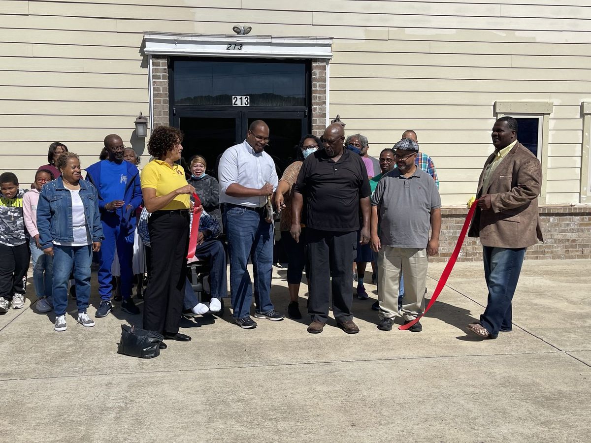 Flint River members gathered outside the front doors at 213 Winchester Road for a ribbon cutting